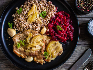 Roasted meat, buckwheat and beetroots on wooden table