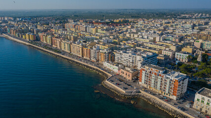 Obraz na płótnie Canvas Beautiful panoramic aerial view photo from flying drone on Molfetta waterfront and the old town from a great height.Port with ships and yachtsand the Molfetta new city at sunrise.Apulia,Italy (Series)
