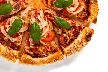 Pizza with ham, mozzarella, champignon, tomatoes and onion on white background
