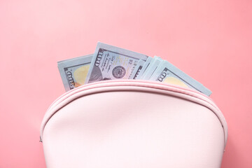 Close up of cash in wallet on pink background .