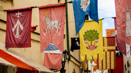 Medieval flags hanging in old town's alleyway.