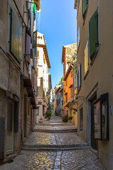 Fototapeta na wymiar Morning walk in empty Croatian city of Rovinj.Picturesque narrow cobblestone streets,colorful facades,small shops,beautiful European cityscape.Summer holiday background.Real estate concept.