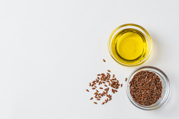 Flaxseed oil flaxseeds in glass containers on a white background with copy space, top view