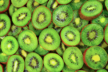 Top view of heap of sliced kiwi as textured background.