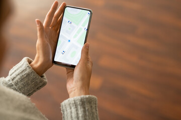 Hands of contemporary young female in grey knitted sweater using smartphone