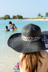 Women watching mom and daughter playing in the ocean.