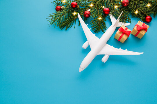 Christmas Travel Planning. Traveling As Gift. White Blank Model Of Passenger Plane And Gift Box On Blue Background. Top View Or Flat Lay. Copy Space.