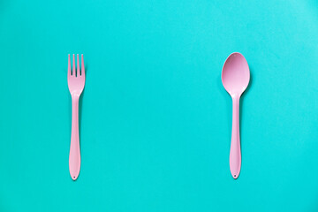 pink spoon and fork on green table background, food and healthy concept