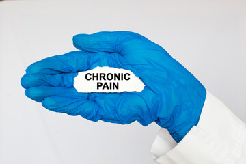 Doctor holding a card with text CHRONIC PAIN, medical concept