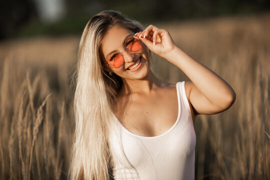 beautiful young female in sunglasses in summer in the field