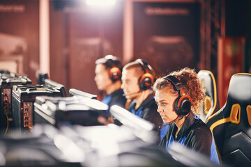 Young professional cybersport team wearing headphones participating in eSport tournament, playing...