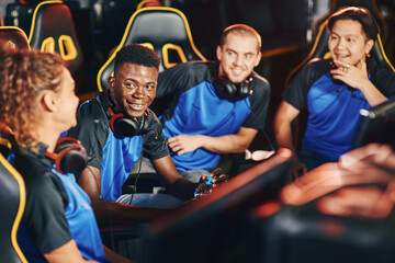 Happy professional multiracial cybersport team talking and discussing game while participating in eSport tournament © Friends Stock