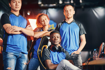Group of multiracial professional cybersport gamers looking at camera and smiling, participating in...