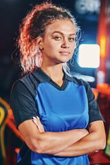 Portrait of a young mixed race female cyber sport gamer keeping arms crossed and looking at camera, posing after eSports tournament or competition © Friends Stock