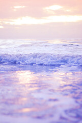Ocean wave on a sandy beach in the morning, Violet tone