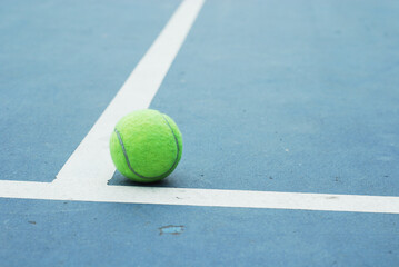 Tennis ball on concrete blue field with white line