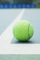 Tennis ball on concrete blue field with white line