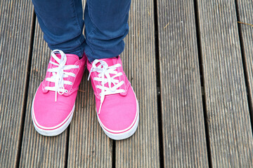 Woman in pink / purple canvas vintage shoes and blue jeans.