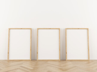 Three vertical wooden frame poster on wooden floor with white wall. 3 frame mock up. 3D illustration.