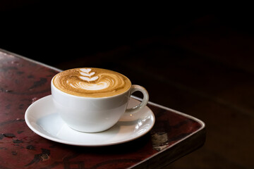 morning coffee in white cup on wooden table in cafe
