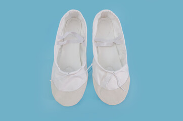 White ballet flats for dancing isolated on blue background. Shoes for trainers in the fitness room.