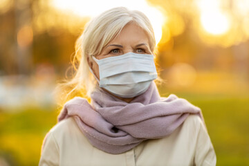 Portrait of senior woman wearing protective face mask outdoors