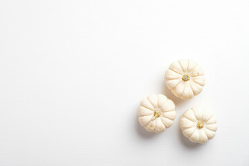 Small decorative pumpkins on white background. Flat lay, top view. Autumn fall, harvest, thanksgiving concept.