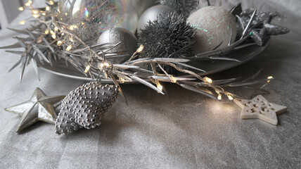 closeup of stylish silver grey christmas decoration plate with light chain and three stars
