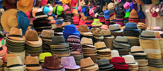 Stacks of fashionable hats in different styles and colors in the hat shop - obrazy, fototapety, plakaty