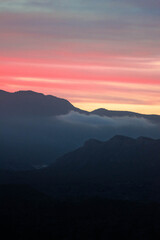 Montañas entre un cielo de atardecer rojo con nubes
