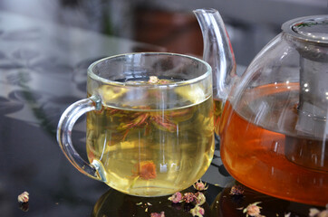 Transparent glass mug with tea. Herbal green tea. Delicious and healthy drink.