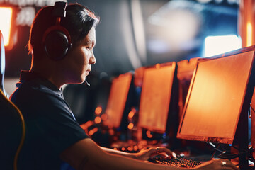 Male professional cybersport gamer wearing headphones playing online video game, participating in eSport tournament © Friends Stock