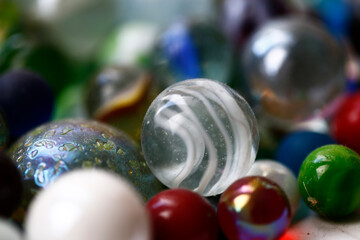 Macro shot of white glass marble in a bowl of marbles.