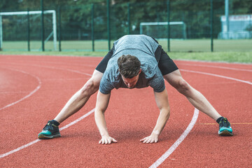 Young Caucasian man doing stretching  exercises, open legs