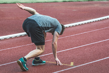 Young Caucasian man in a sprint start position