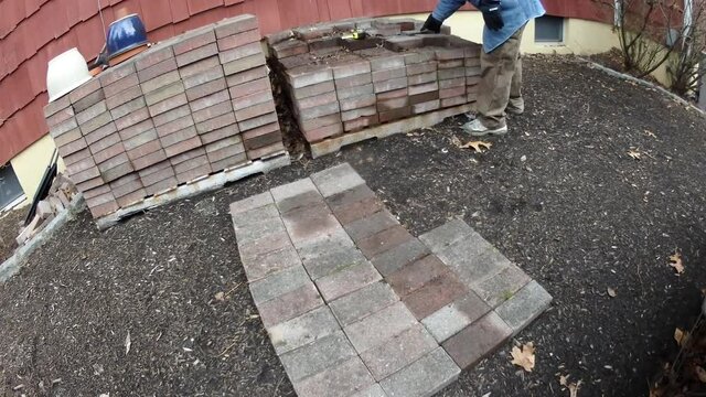 time lapse woman building a platform with red bricks in the backyard