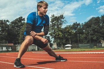 Obraz premium Young Caucasian man doing strength exercises, side step lunges