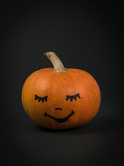 Pumpkin with a cute face on a black background.