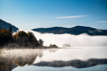 Cold morning fog over beautiful lake in autumn