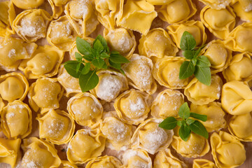   raw tortellini and basil leaves