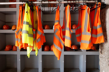 yellow work vests are hanging on a hanger.