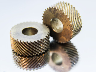 Two brass gear, old mechanism, is  reflecting  on the light background.