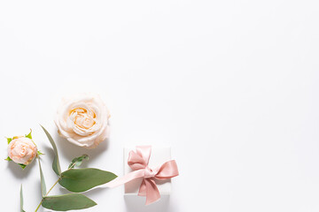 Minimalism style festive composition with gift box for jewelry rose flowers and eucalyptus twig. Greeting or invitation card mock up.