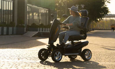 Woman tourist riding a four wheel mobility electric scooter on a city street.