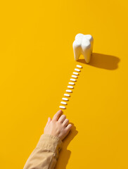 female hand arranges a row of pills to the tooth