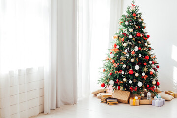 Christmas tree by the window with gift decor for the new year interior of the holiday house