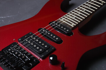 Fototapeta na wymiar Red electric guitar on dark concrete background, close-up, selective focus