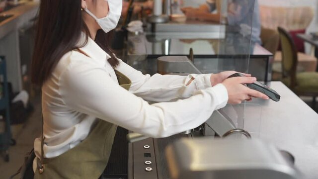 Customer use wireless credit card with EDC at cashier in restaurant.