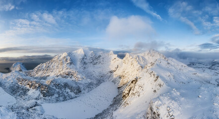 Panoramic view on the mountain range in Norway. Winter landscape from air. Rocks and snow.
