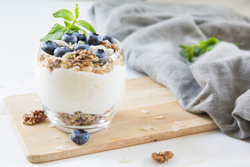 Healthy blueberry and walnut parfait in a glass on a white background